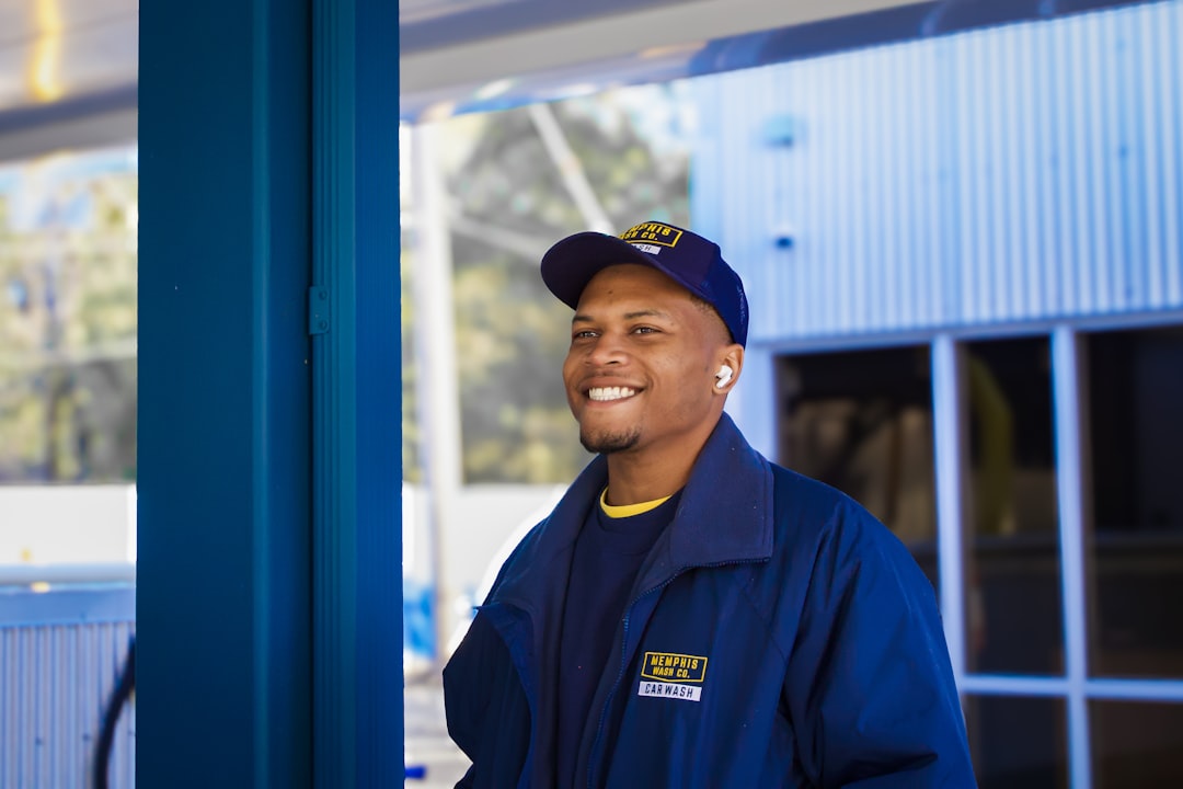 A man in a blue uniform standing in front of a building